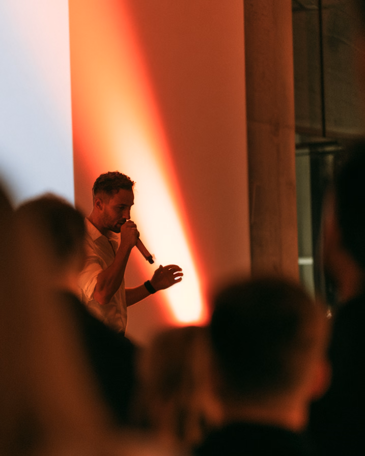 A speaker with a microphone in front of the room at a chapter talk