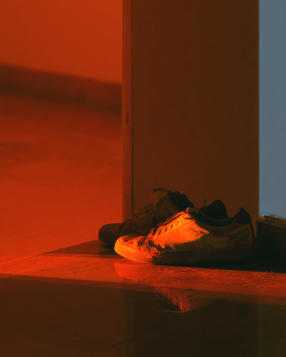 Running shoes by the door in low light